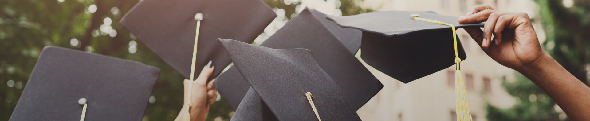 A group of graduates throwing graduation caps in the air
