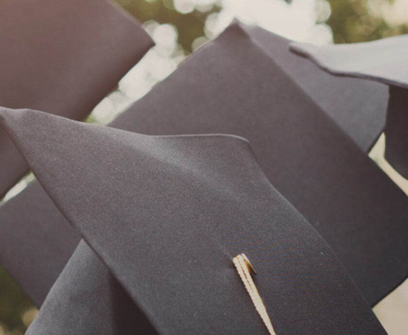 A group of graduates throwing graduation caps in the air